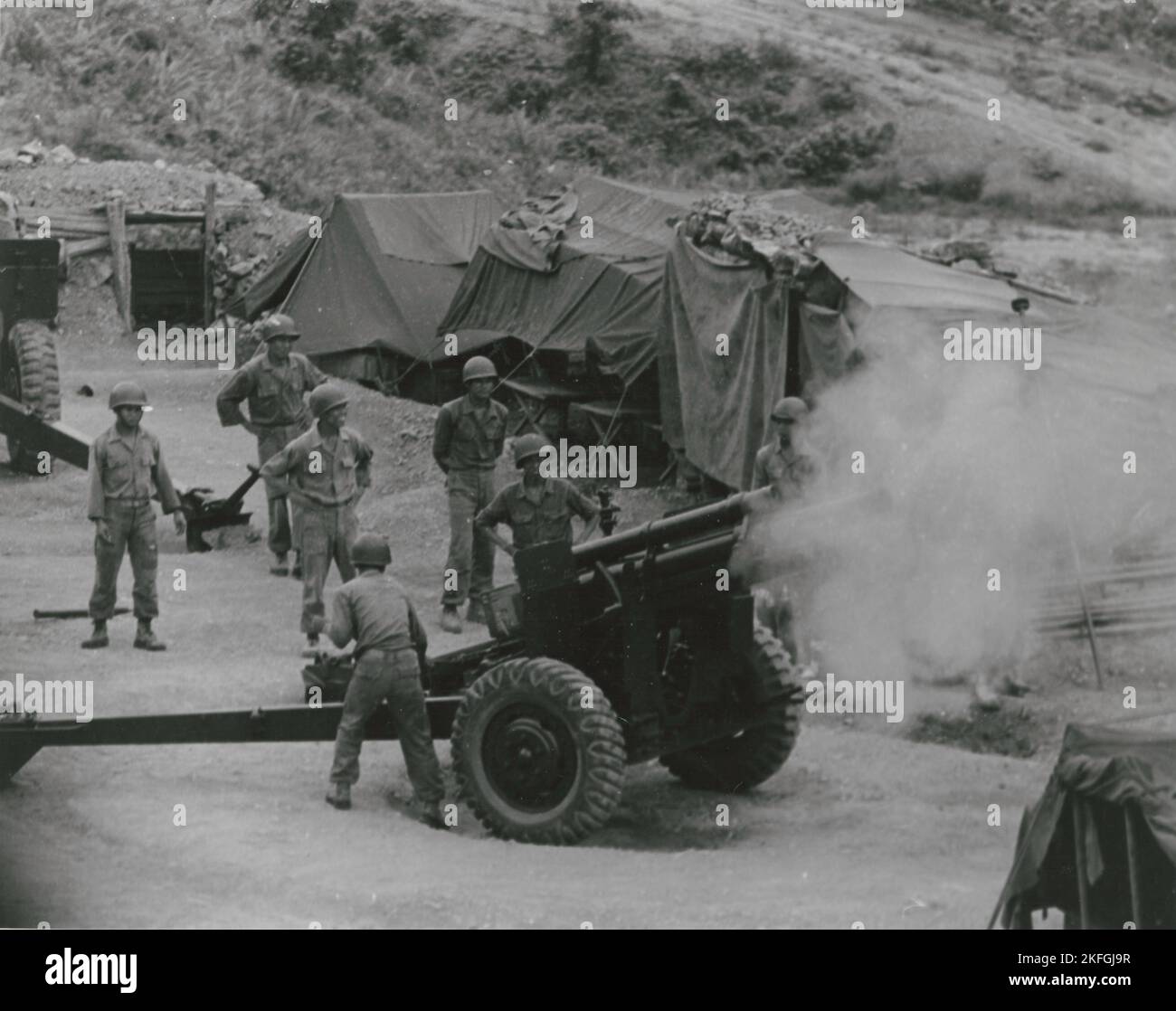 Artiglieri vietnamiti sparano da una posizione di montagna durante l'addestramento sul campo, 1962. Foto Stock