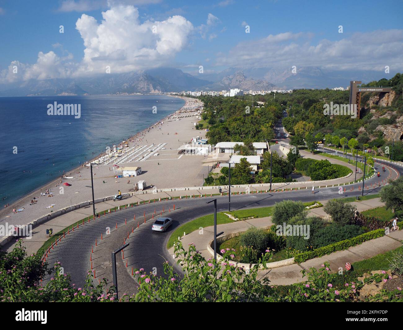 Spiaggia di Konyaaltı e la strada asfaltata curva che conduce alla beach.in Antalya, Türkiye. Foto Stock