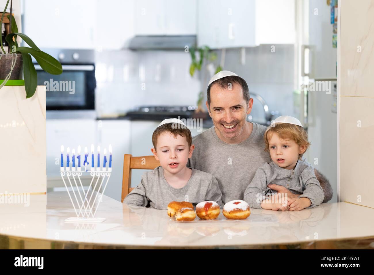 Padre e figli con la menorah celebrano hanukkah - festa religiosa ebraica Foto Stock