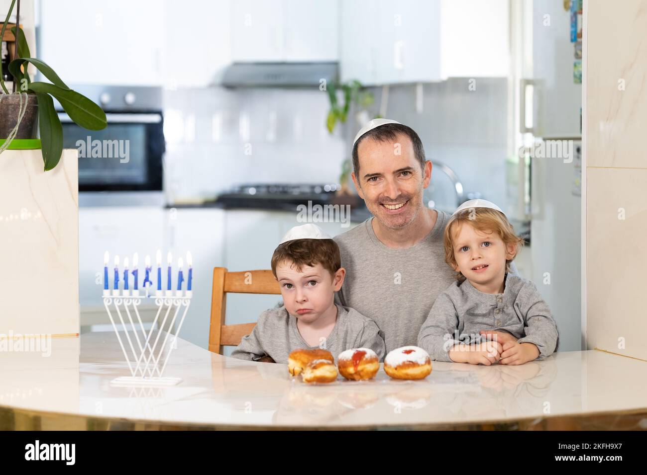 Padre e figli con la menorah celebrano hanukkah - festa religiosa ebraica Foto Stock