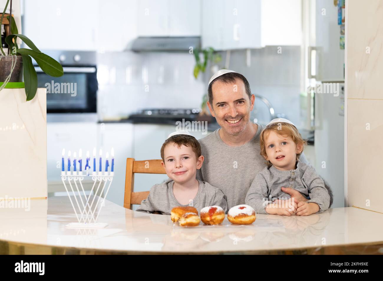 Padre e figli con la menorah celebrano hanukkah - festa religiosa ebraica Foto Stock