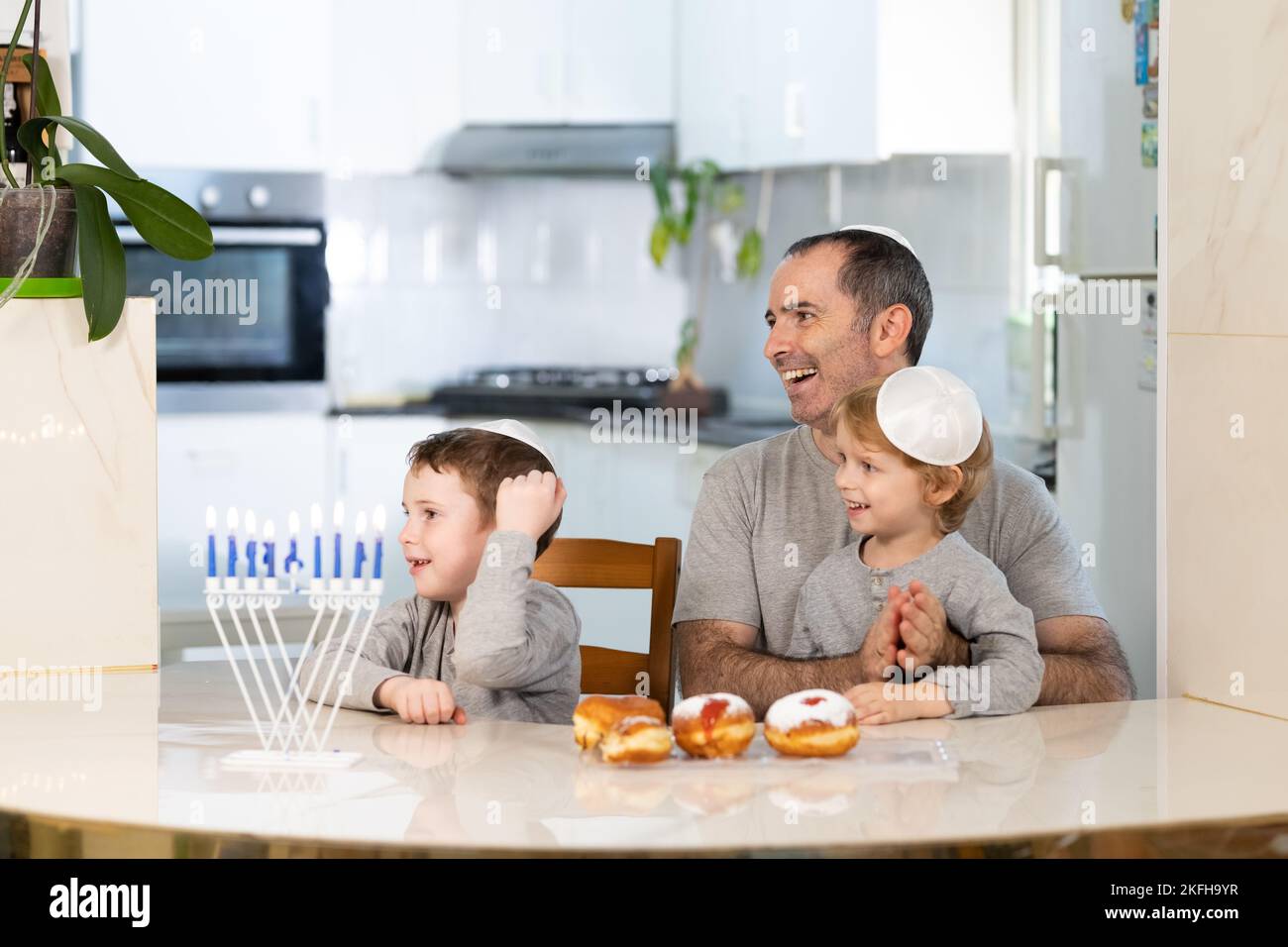 Padre e figli con la menorah celebrano hanukkah - festa religiosa ebraica Foto Stock