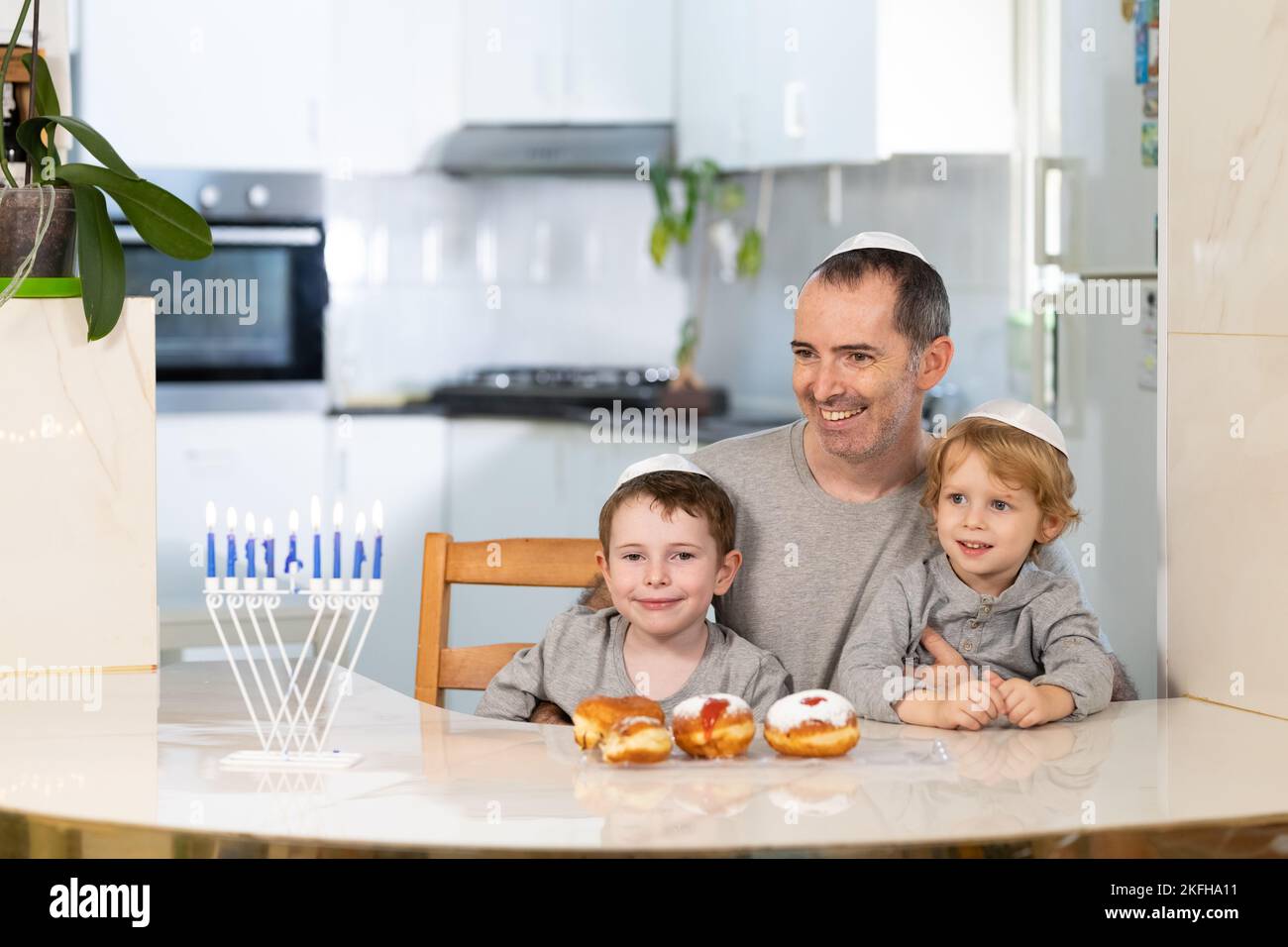 Padre e figli con la menorah celebrano hanukkah - festa religiosa ebraica Foto Stock
