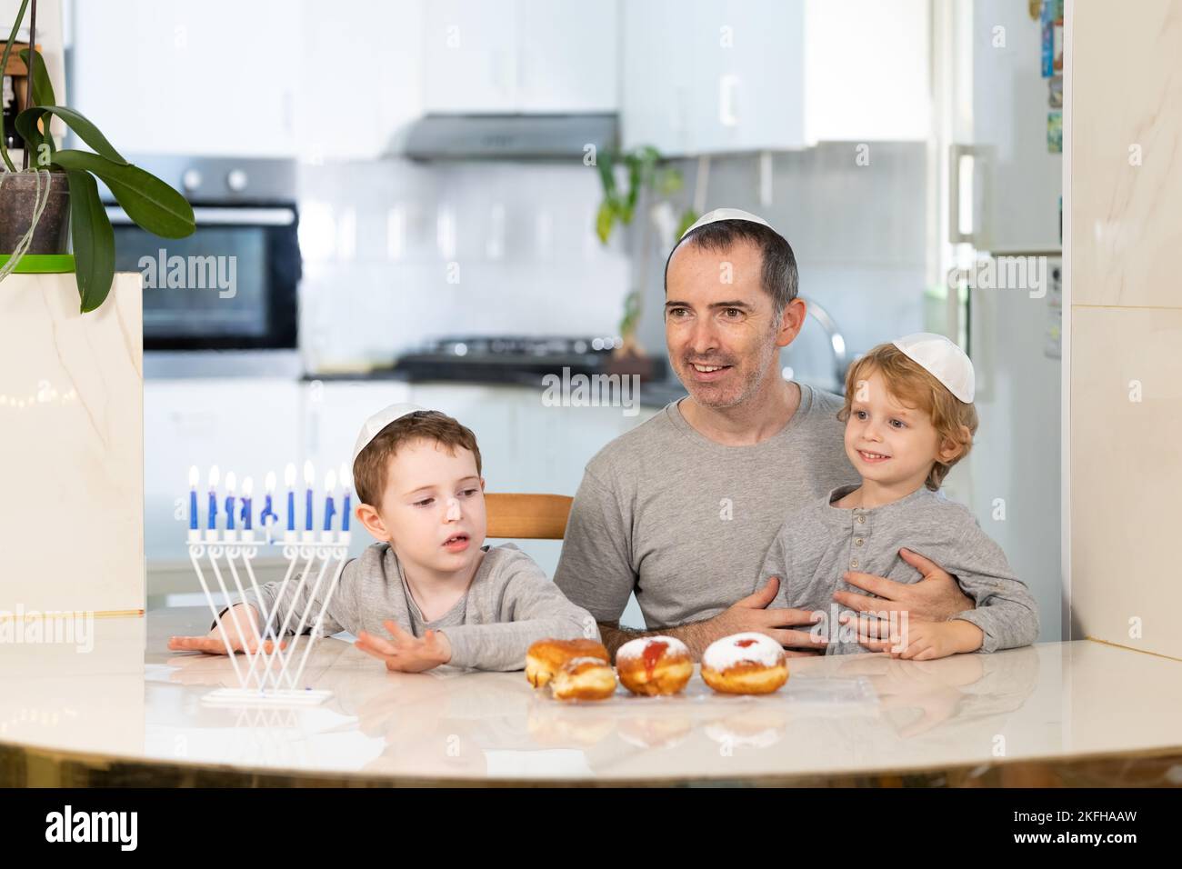 Padre e figli con la menorah celebrano hanukkah - festa religiosa ebraica Foto Stock