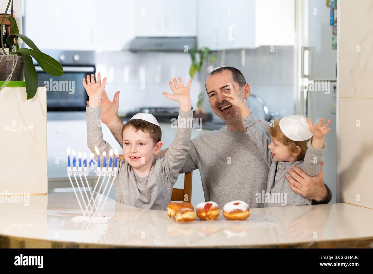 Padre e figli con la menorah celebrano hanukkah - festa religiosa ebraica Foto Stock