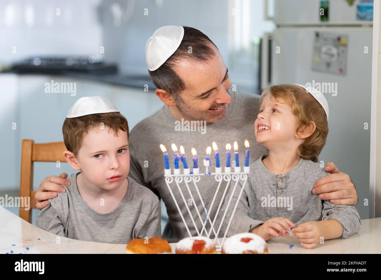 Padre e figli con la menorah celebrano hanukkah - festa religiosa ebraica Foto Stock
