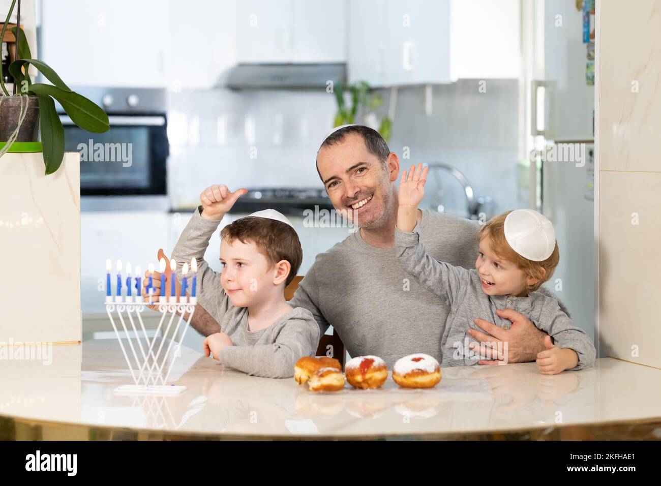 Padre e figli con la menorah celebrano hanukkah - festa religiosa ebraica Foto Stock