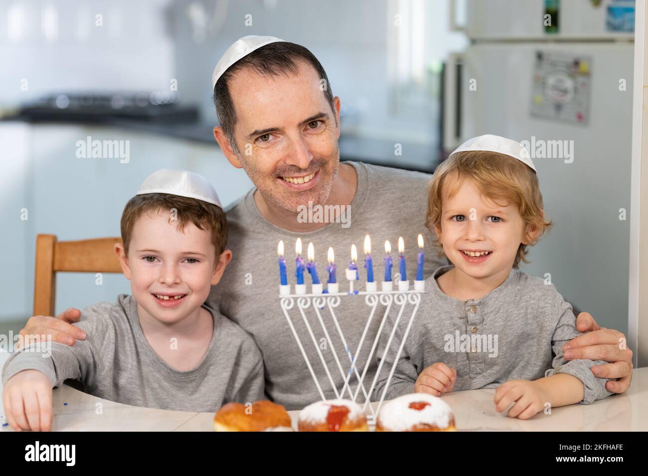 Padre e figli con la menorah celebrano hanukkah - festa religiosa ebraica Foto Stock