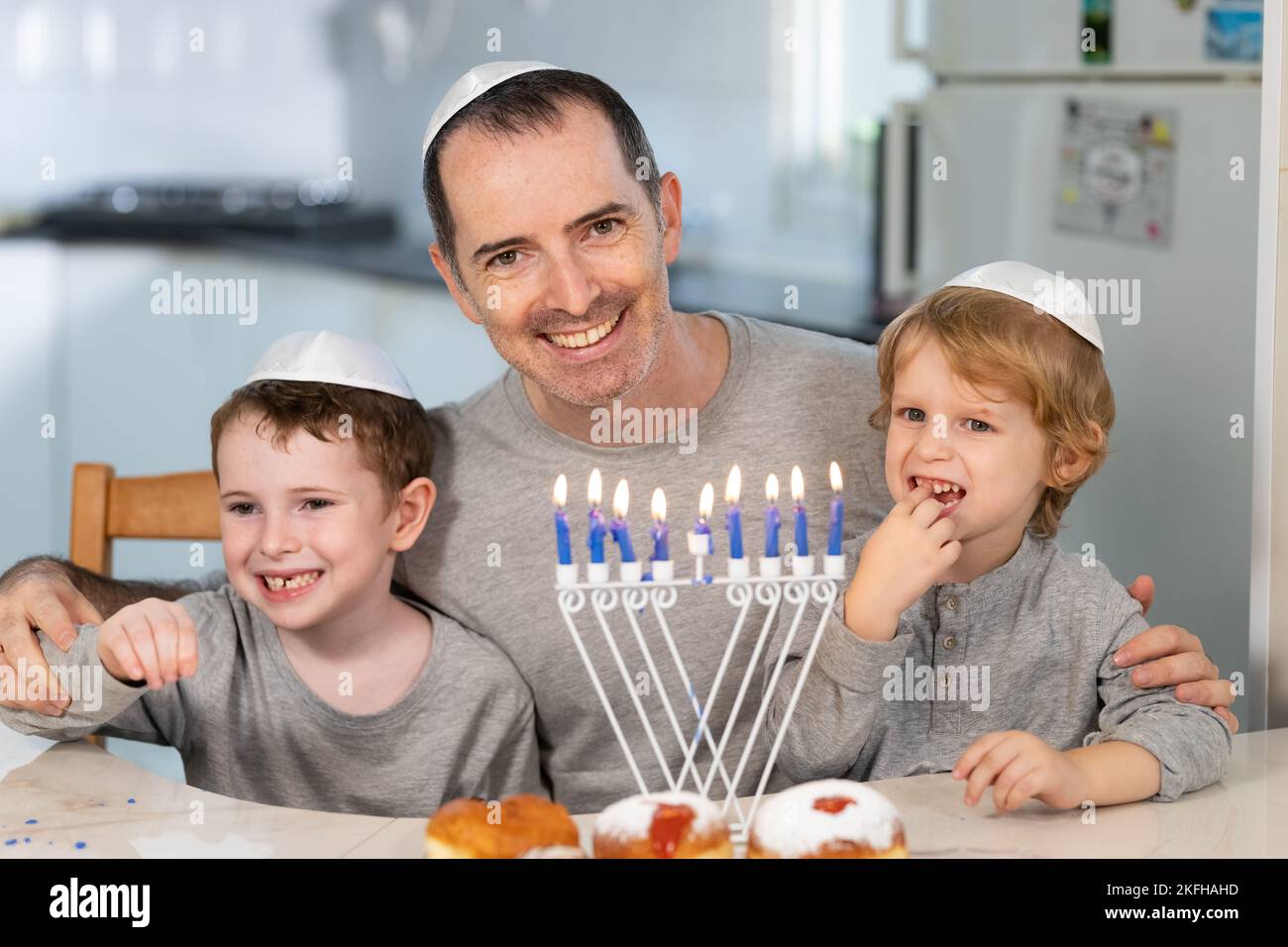 Padre e figli con la menorah celebrano hanukkah - festa religiosa ebraica Foto Stock