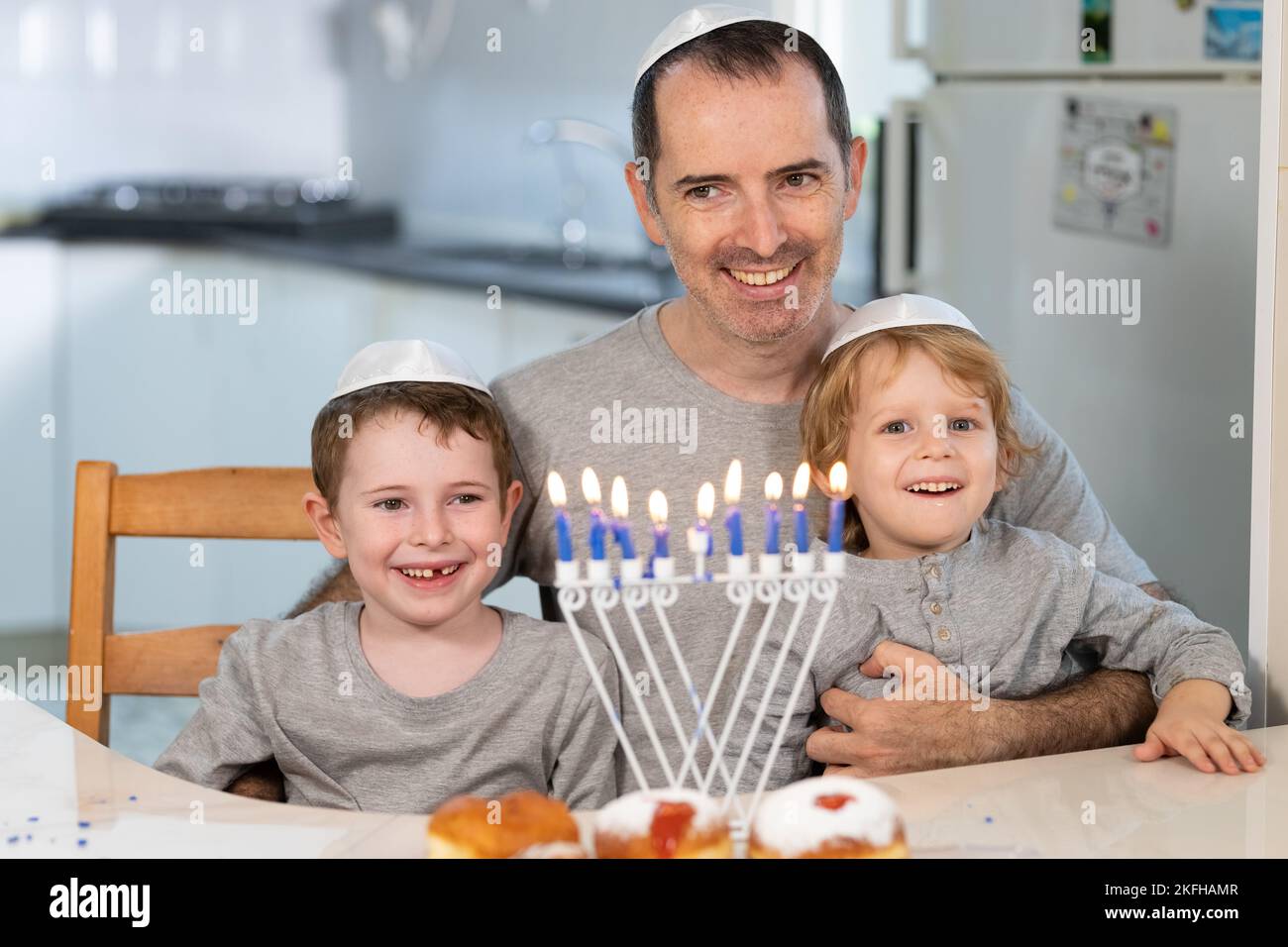 Padre e figli con la menorah celebrano Hanukkah - festa religiosa ebraica Foto Stock