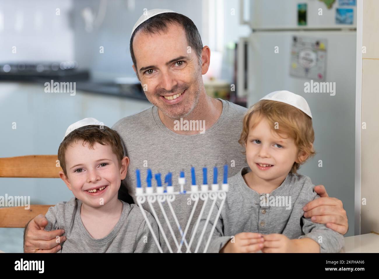 Padre e figli con la menorah celebrano Hanukkah - una festa religiosa ebraica Foto Stock