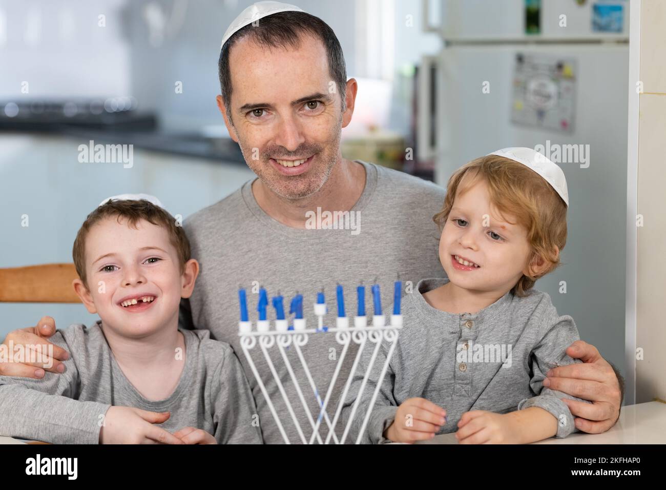 Padre e figli con la menorah celebrano hanukkah - festa religiosa ebraica Foto Stock