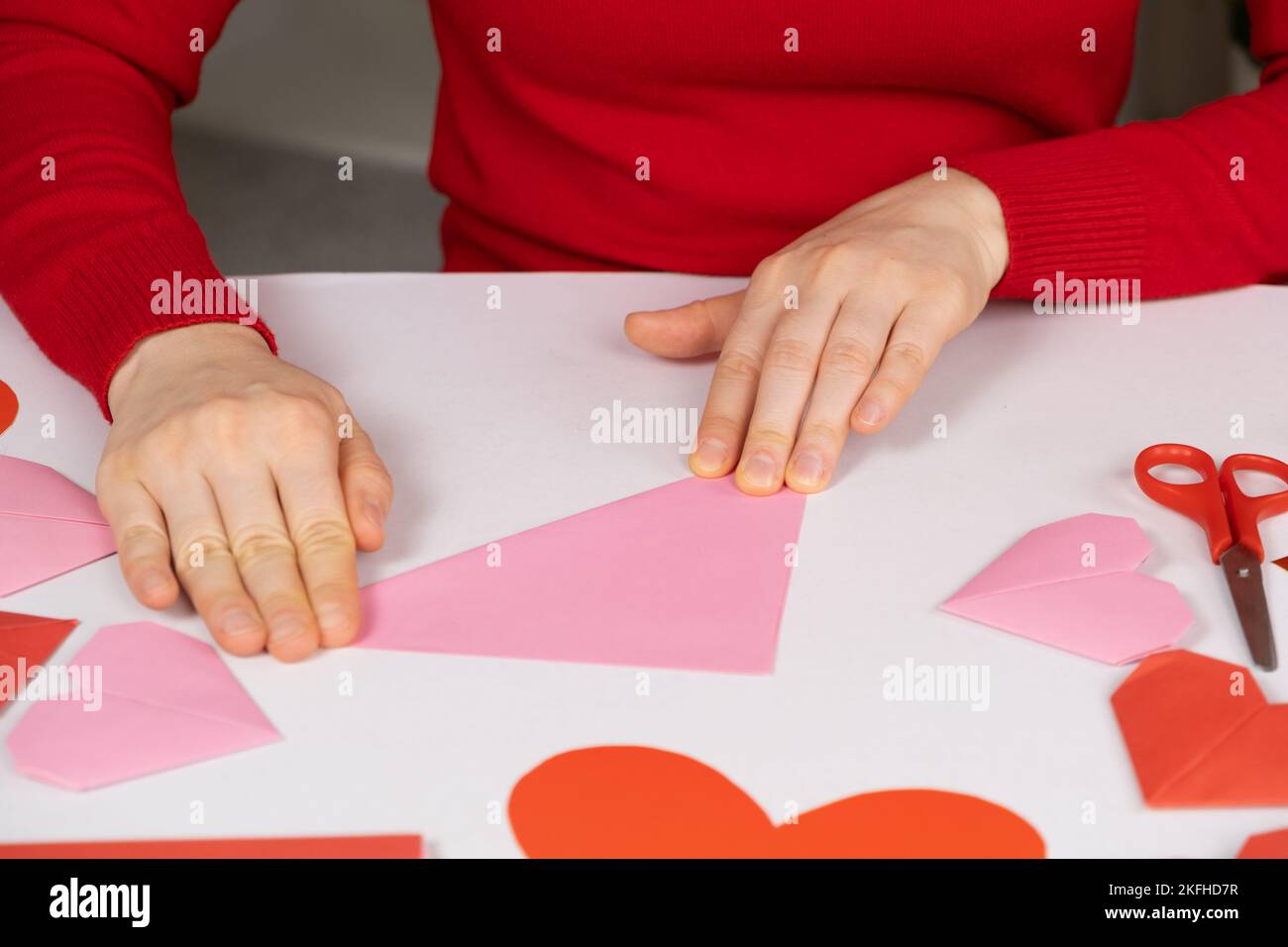 Creare cuori di origami per San Valentino. Artigianato fatto di carta con le proprie mani. Foto Stock