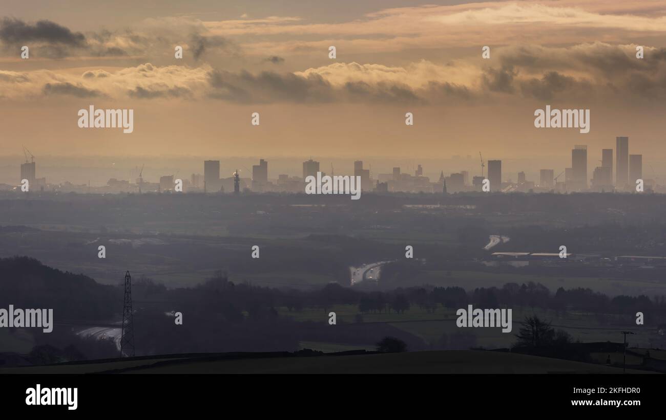 Profilo dello skyline di Manchester in lontananza. Grattacieli di Manchester che si innalzano attraverso la nebbia. Spettacolare paesaggio Moody che guarda su Manchester Foto Stock