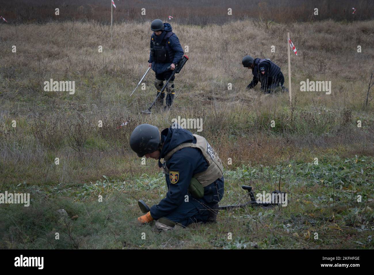 Diversi investigatori hanno visto condurre lavori di sminamento in un campo. Dopo la liberazione della capitale regionale meridionale dell'Ucraina Kherson, il governo ucraino ha lavorato intensamente per rimuovere le mine terrestri nel territorio liberato. Circa 5000 esplosivi sono stati trovati e distrutti dalla liberazione. Con la mancanza di robotica sufficiente, il processo di sminamento viene condotto manualmente e ciò richiederebbe almeno diversi mesi per ripulire l'intera città di Kherson. Foto Stock