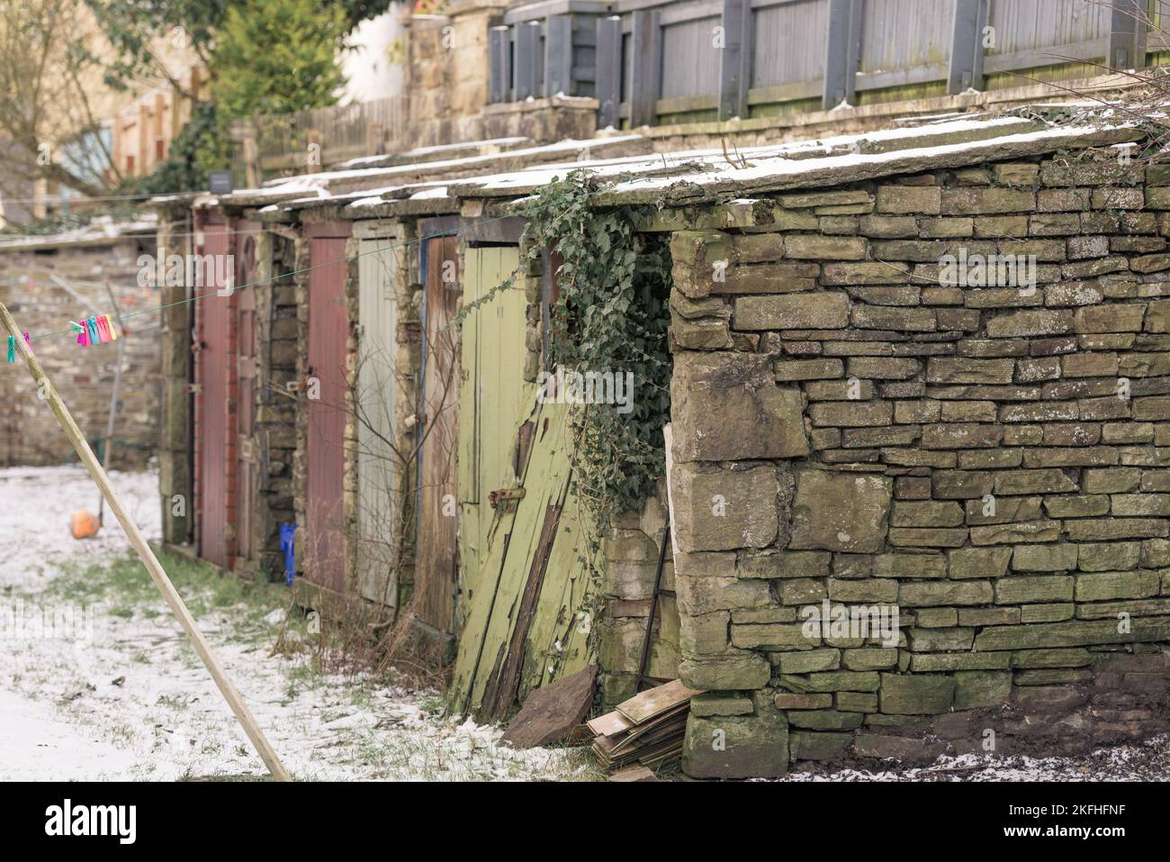 Vecchie case e bagni fuori capannoni lungo una strada sul retro in Inghilterra. Porte colorate marciume. Foto Stock