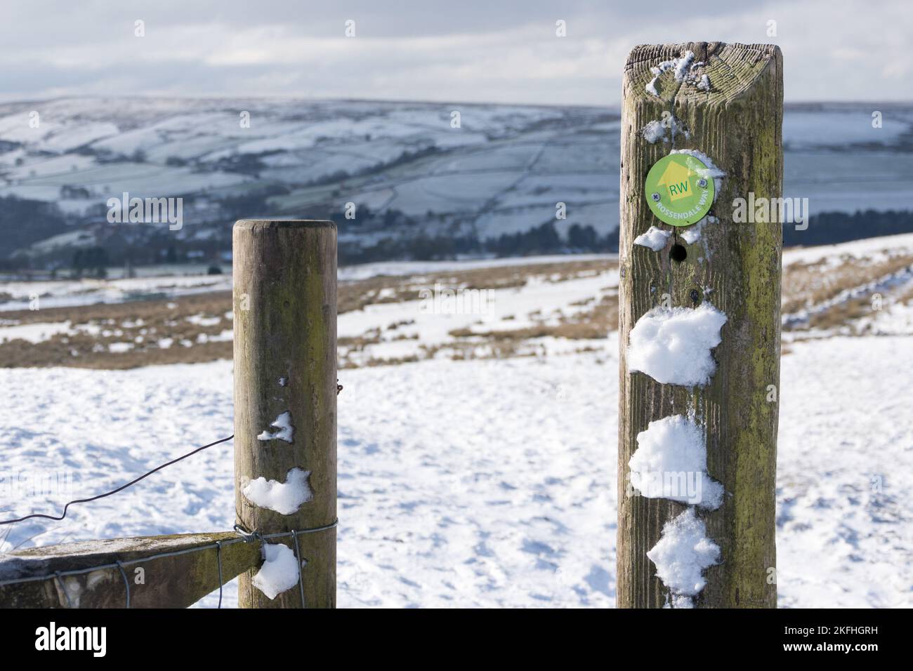 Sentiero ROSSENDALE Way segnavia su un palo di recinzione nella neve sulle brughiere nei pressi della Valle di Rossendale. Guardando sopra la brughiera piena di neve. Foto Stock