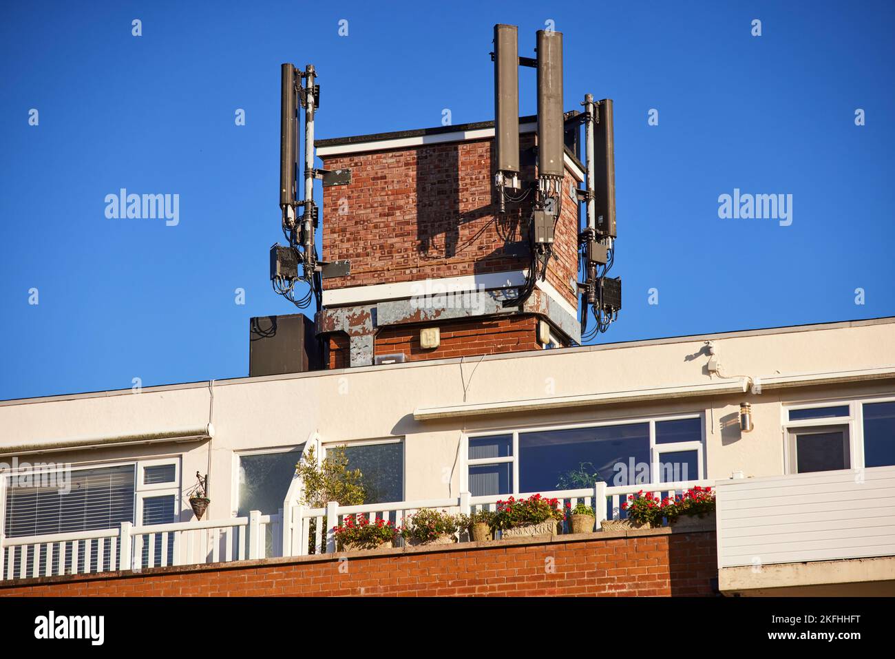 Telefono cellulare ariels in cima a un piccolo condominio a Southport, Lancashire. Foto Stock