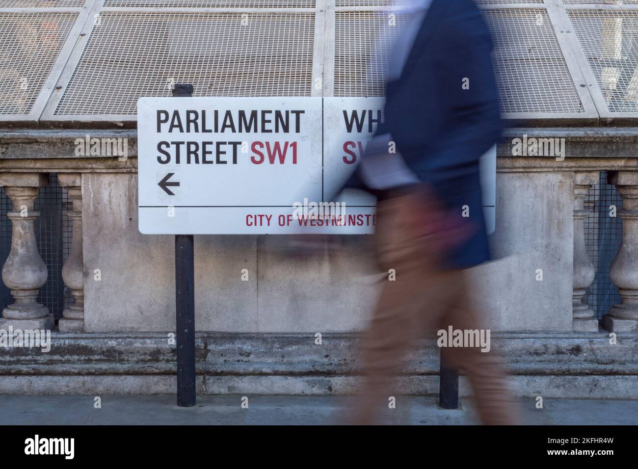 Persona che passa davanti a un cartello che indica l'incrocio tra Parliament Street e Whitehall, City of Westminster, SW1, Londra, Regno Unito. Foto Stock