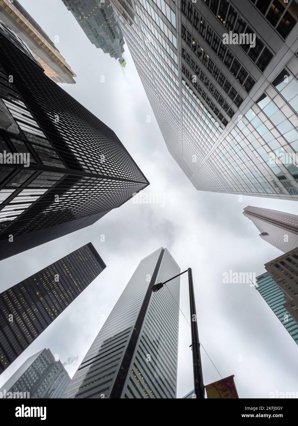 Vista ad angolo basso degli edifici degli uffici nel quartiere finanziario del centro con cielo nuvoloso sullo sfondo Foto Stock