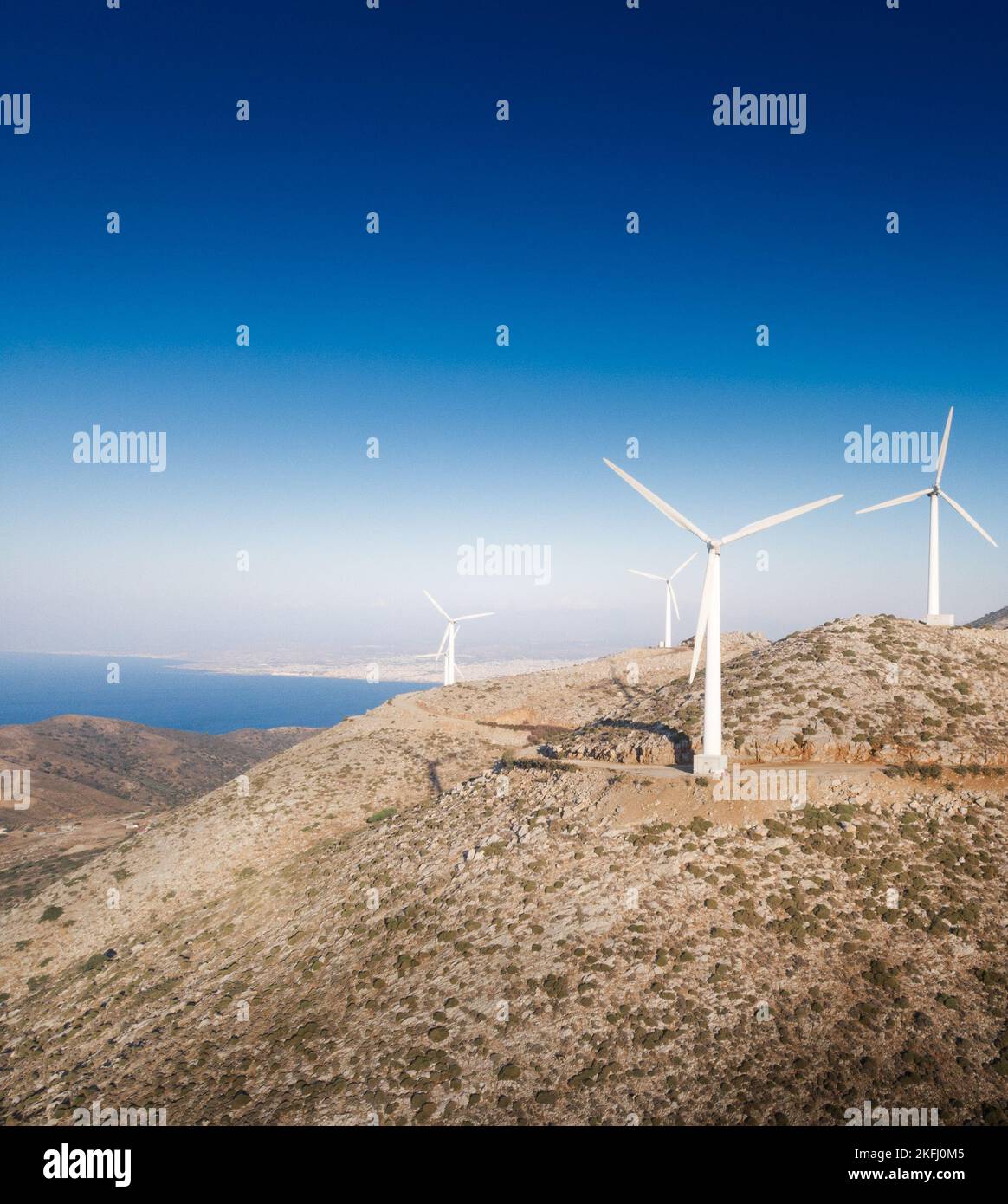 Turbine eoliche sulla montagna contro il cielo blu e vista panoramica del paesaggio durante le giornate di sole Foto Stock
