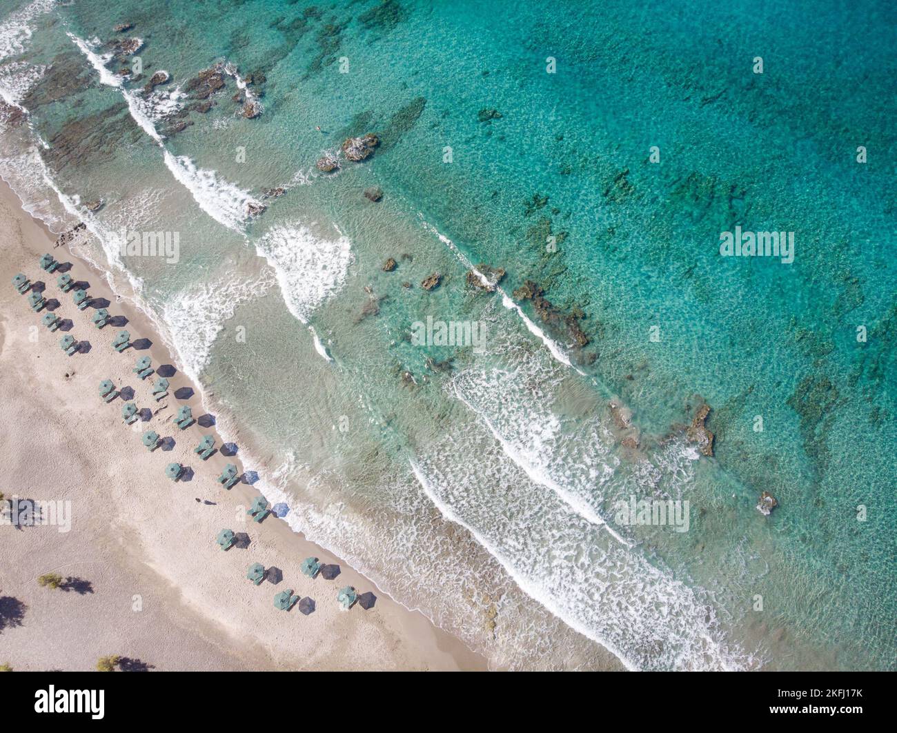 Drone shot di sedie a sdraio e ombrelloni disposti in spiaggia da Seascape durante il clima tropicale Foto Stock
