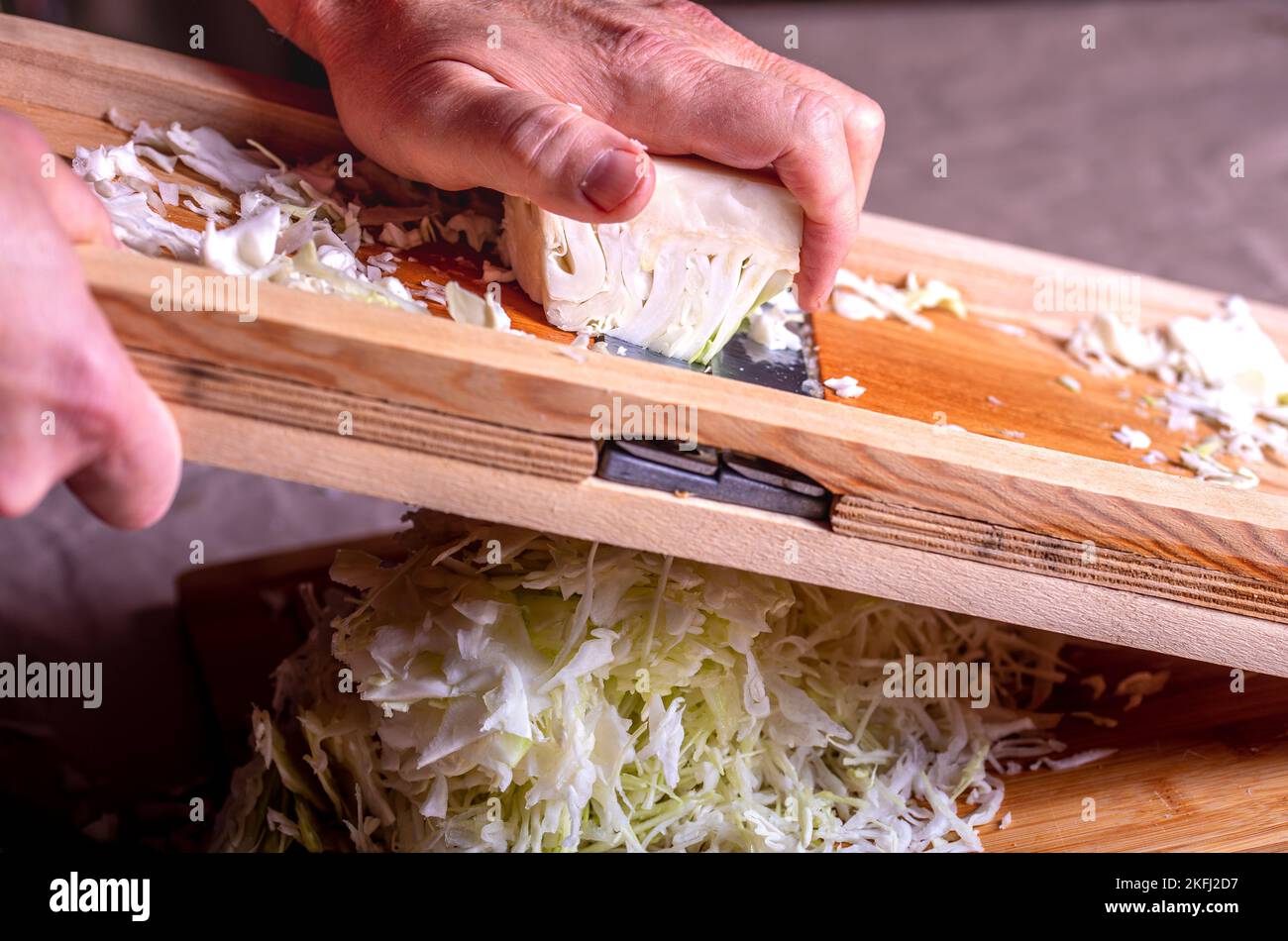 Preparare il cavolo per la fermentazione. Taglio del cavolo sulla taglierina. Crauti fatti in casa. Foto Stock