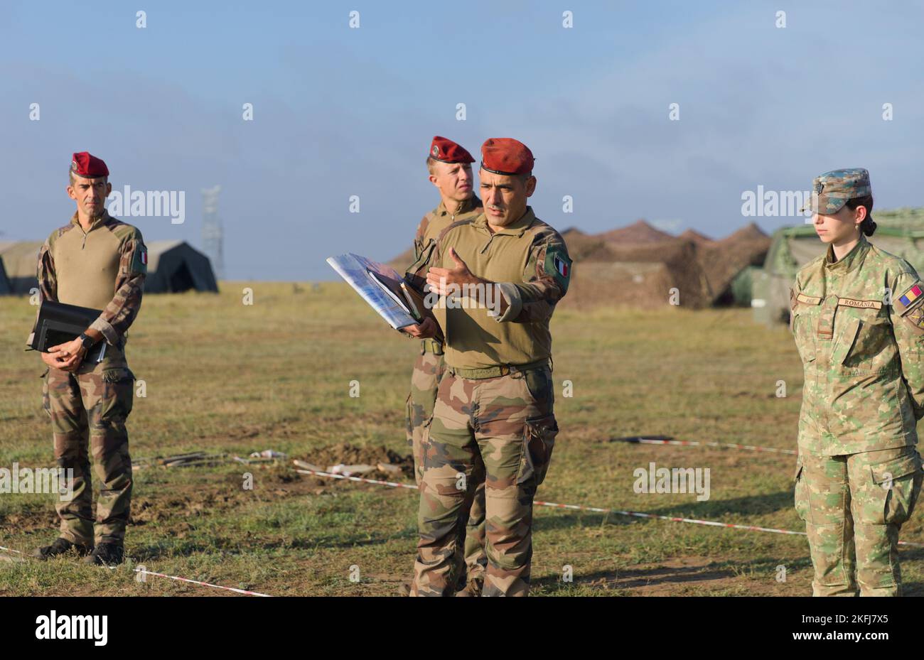 I soldati francesi, assegnati al Gruppo di Battaglia di presenza in avanti e un soldato rumeno, assegnato a 20th battaglione di fanteria, Brigata multinazionale Sud-Est, parlano di manovre durante una prova di concept drill presso Exercise Justice Eagle, Smardan Training Area, Romania, il 18 settembre 2022. Come parte della 101st Divisione Airborne (Air Assault); 1st battaglione, 8th reggimento di fanteria, continua a rafforzare il fianco orientale della NATO e a impegnarsi in esercitazioni multinazionali come Justice Eagle con alleati e partner in tutto il continente europeo per rassicurare gli alleati della nostra Nazione. Foto Stock