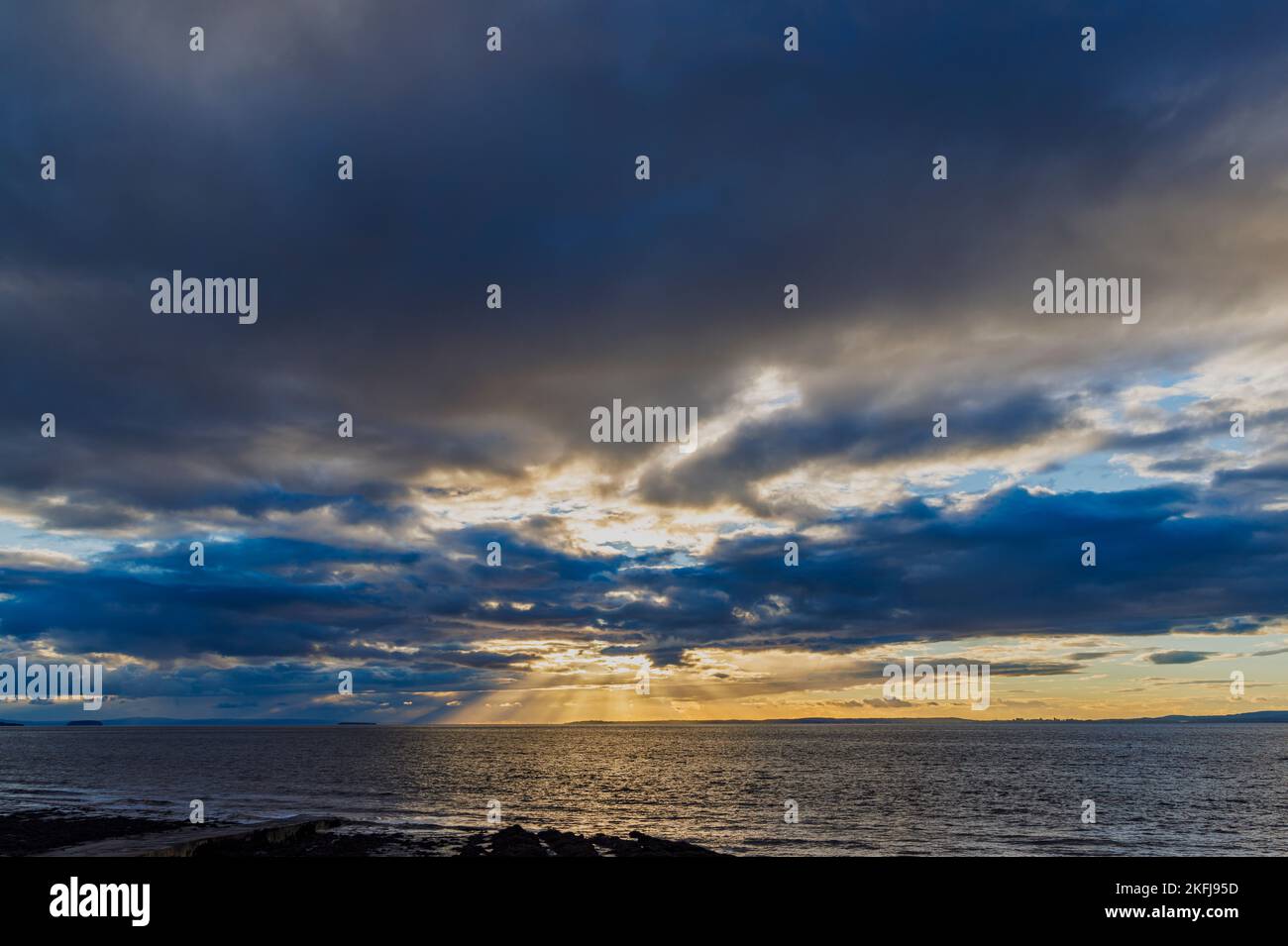 Il sole di setting illuminazione della copertura nuvolosa Foto Stock