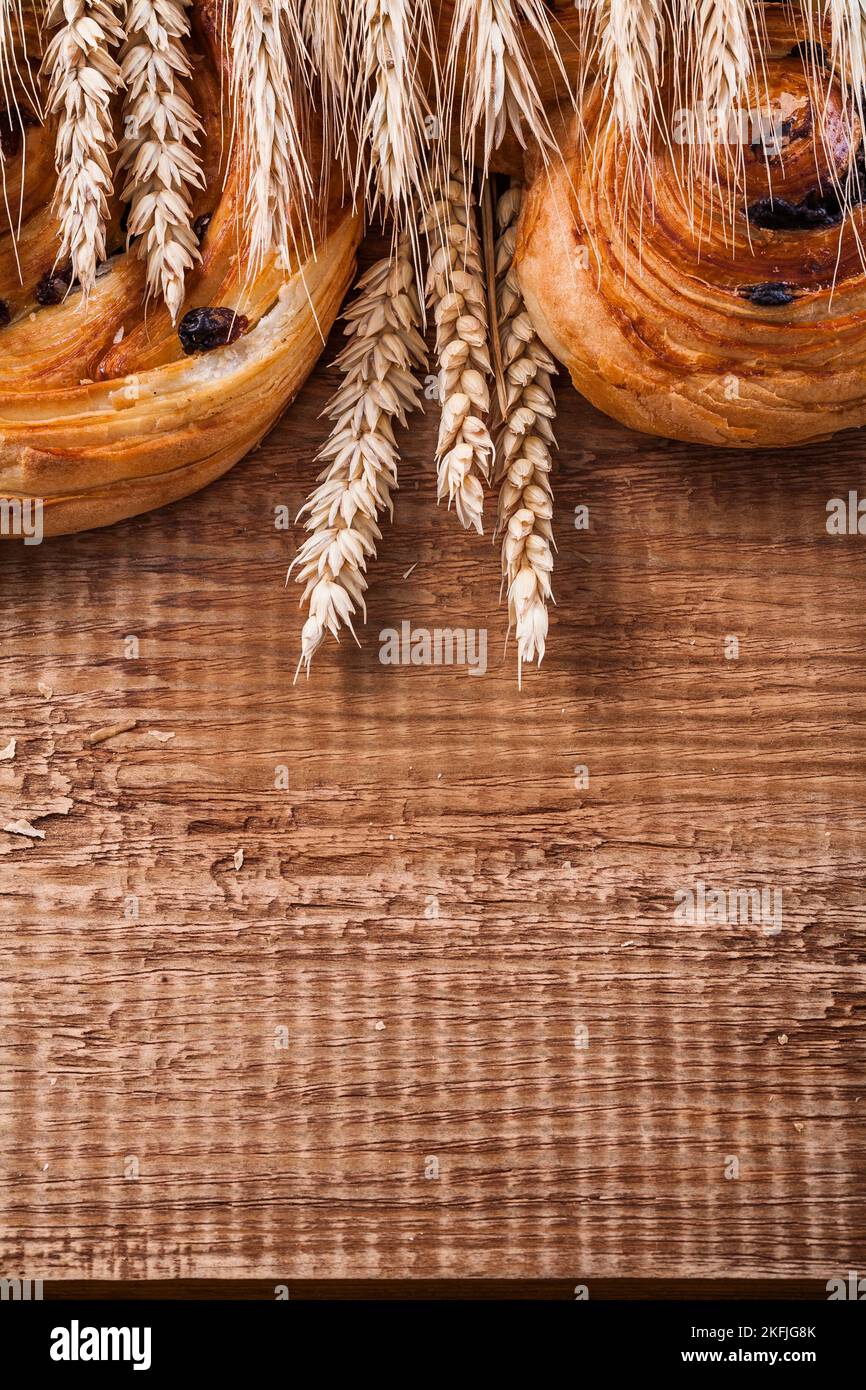 Spighe di grano maturo ricchi prodotti da forno a base di uva passa su un asse di legno di legno di oaken cibo e bevande concetto Foto Stock