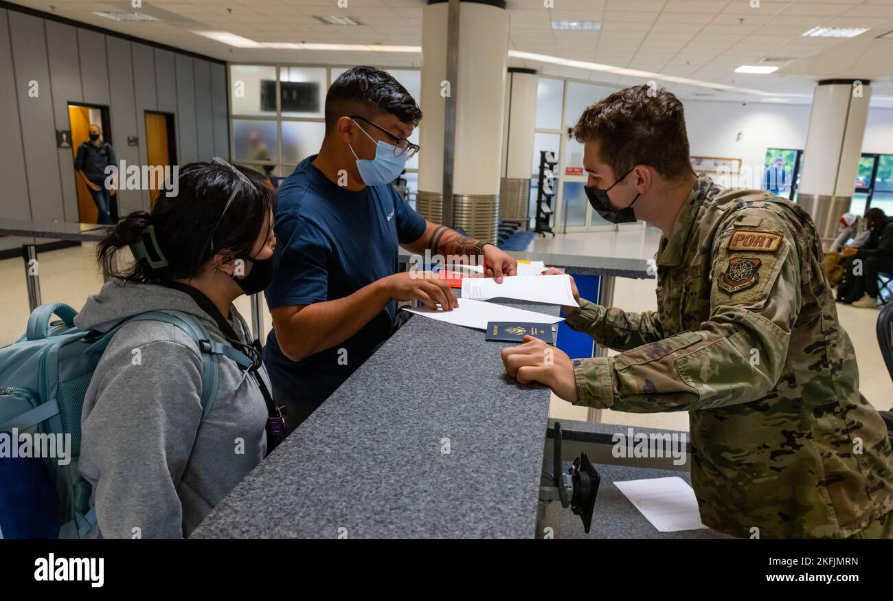 I passeggeri del primo volo Patriot Express passano i documenti con un 727th Air Mobility Squadron Airman presso il terminal passeggeri della Royal Air Force Mildenhall sulla RAF Mildenhall, Inghilterra, 20 settembre 2022. Il volo Patriot Express, noto anche come rotator, è un volo charter commerciale del Dipartimento della difesa che fornisce supporto internazionale ai militari e civili statunitensi e alle loro famiglie che cambiano stazione in modo permanente nel Regno Unito. 100th ARW, Air Mobility Command, Department of Defense, Patriot Express, RAF Mildenhall, USAFE, Foto Stock