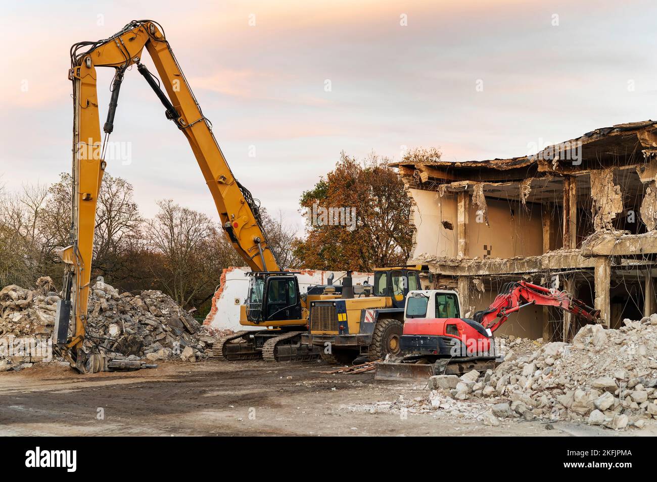 Varie macchine da costruzione durante la demolizione di un edificio Foto Stock