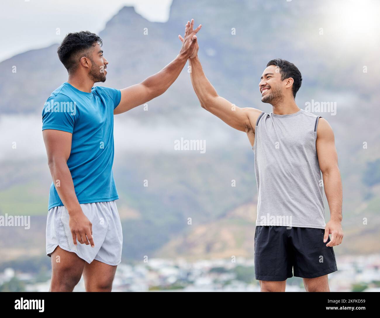High Five, uomo e amici per il fitness all'aperto in estate, lo sport e felice in montagna. Lavoro di squadra, sostegno e mani insieme nel successo, benessere o. Foto Stock