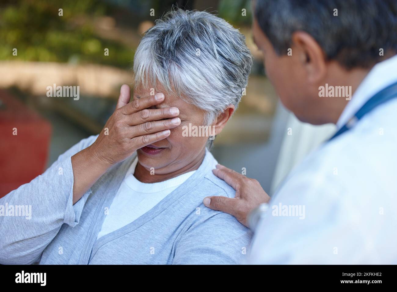 Lei non sopporta di ascoltare. Una donna anziana che riceve alcune cattive notizie dal suo medico. Foto Stock