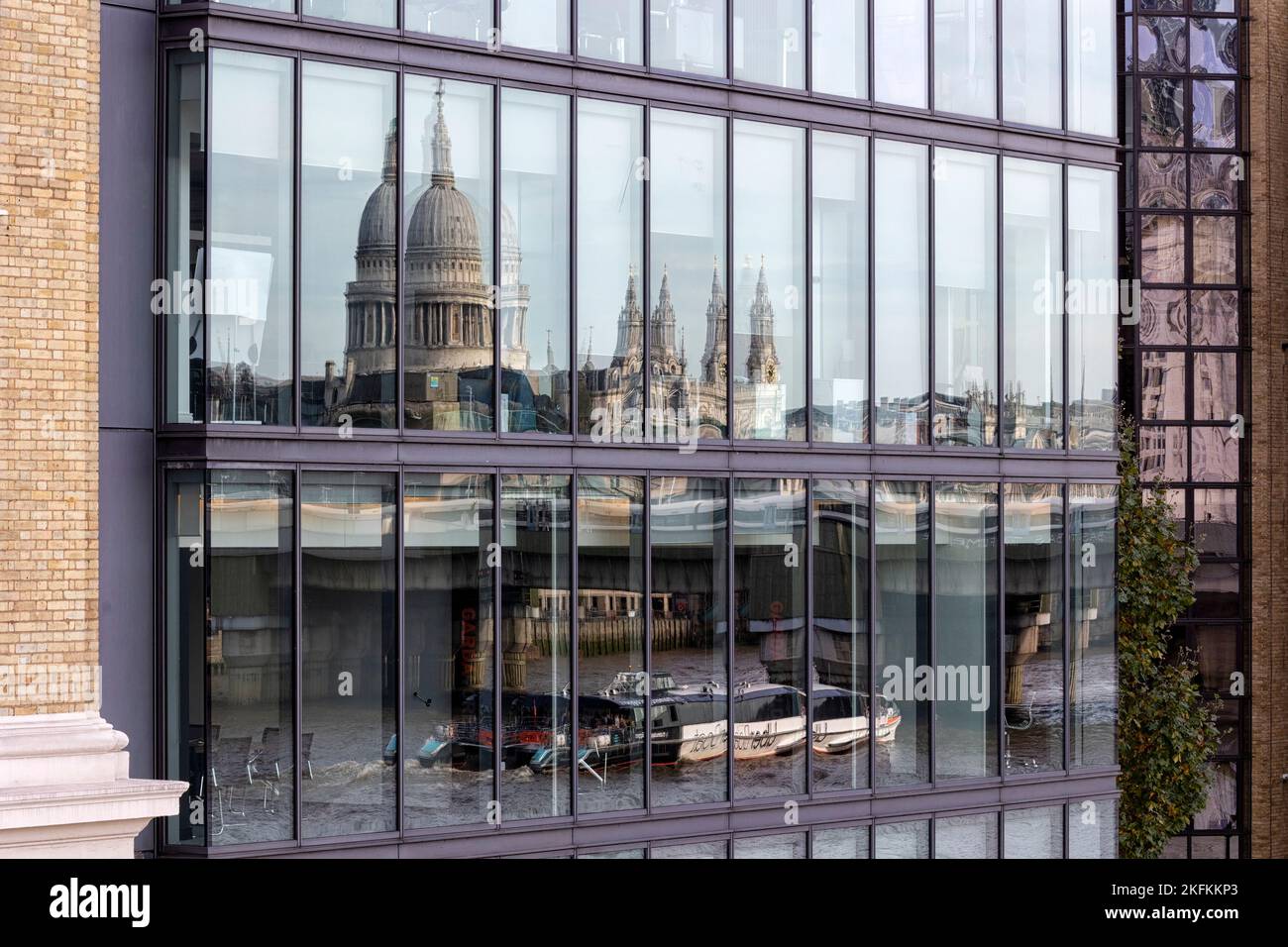 LONDRA, Regno Unito - 29 OTTOBRE 2022: Riflessione della Cattedrale di San Paolo nelle moderne finestre degli uffici della City London con il Tamigi e il vaporetto Foto Stock