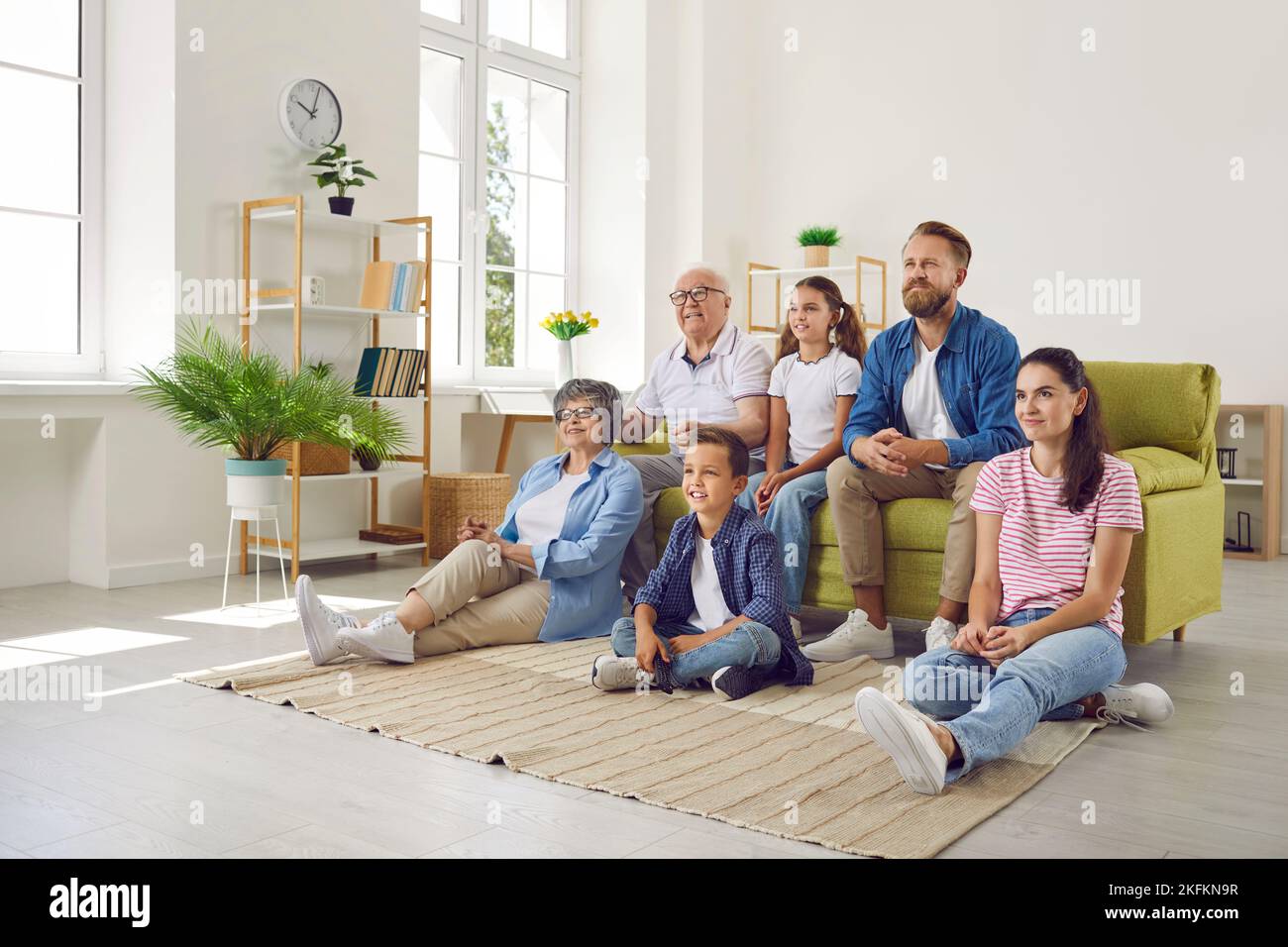 La famiglia multigenerazionale si è riunita a casa per guardare il loro programma televisivo preferito. Foto Stock