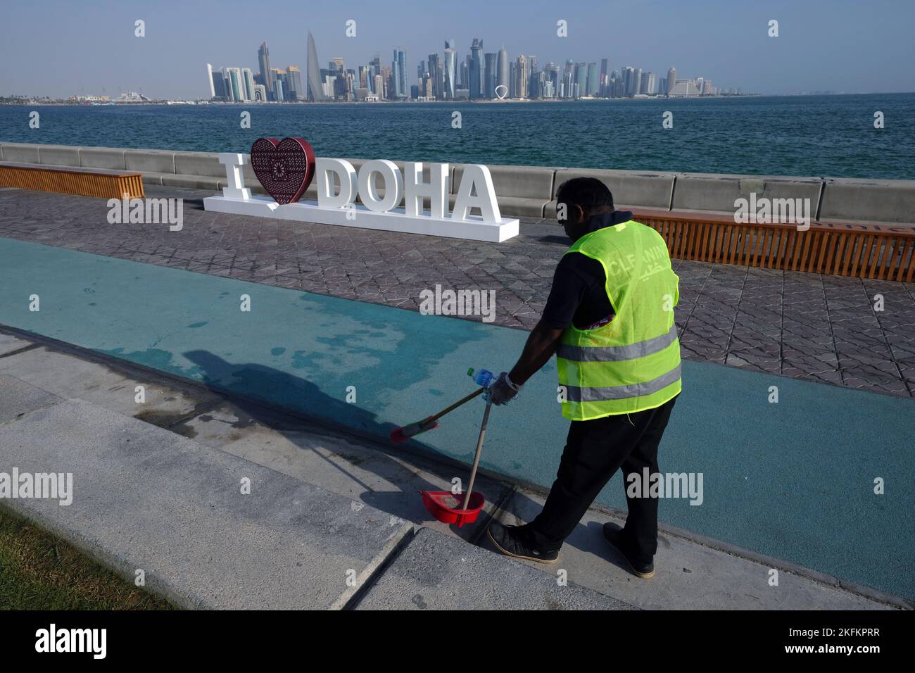 Un lavoratore si avvicina a un cartello i Love Doha a Doha, in vista della Coppa del mondo FIFA 2022 in Qatar. Data immagine: Sabato 19 novembre 2022. Foto Stock