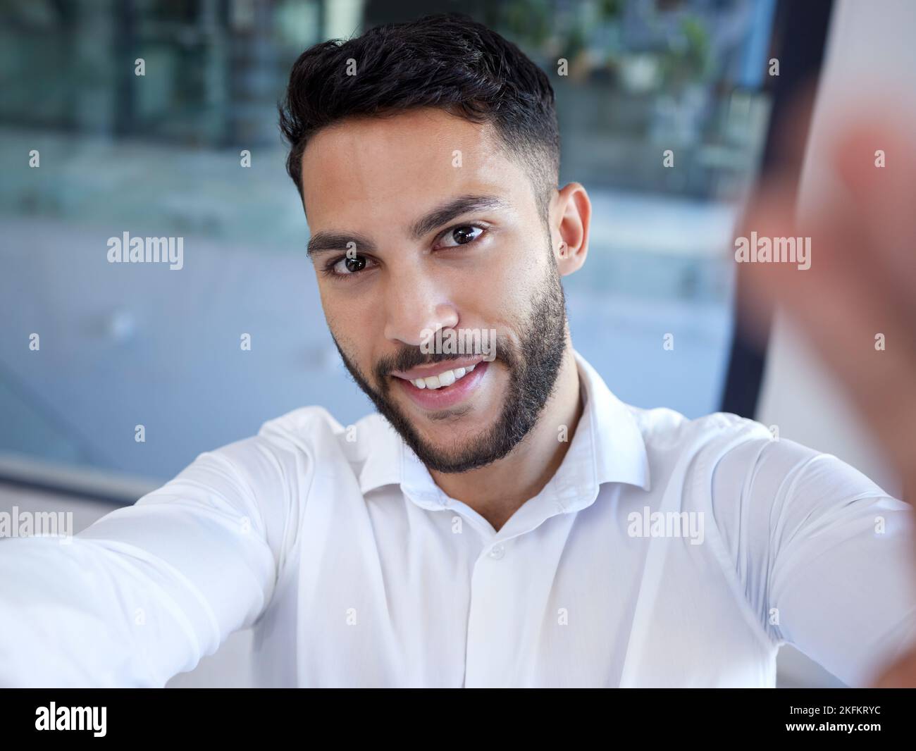 Uomo d'affari, sorriso ritratto e selfie in ufficio per social media, profilo o aggiornamento di stato. Uomo felice faccia dipendente sorridente nella felicità per Foto Stock