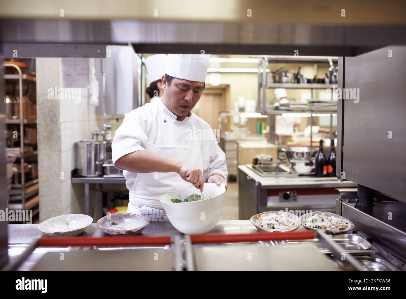 Preparazione per il servizio. Chef preparano un servizio di pasto in una cucina professionale. Foto Stock