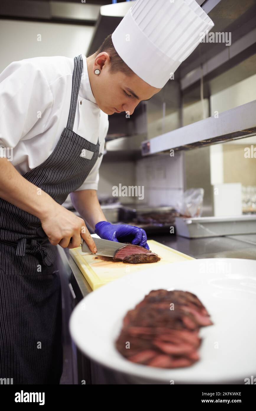 La presentazione è tutto. Gli chef preparano un servizio di pasto in una cucina professionale. Foto Stock