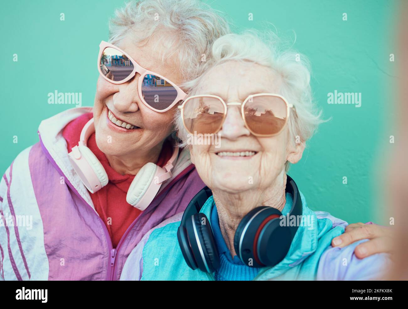 Donne anziane, amici di moda e selfie retrò con occhiali da sole, cuffie e abiti vintage in pensione. Ritratto di gente anziano fredda insieme per Foto Stock