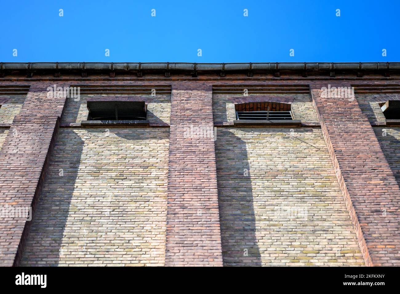 Parete della casa fatta di mattoni di colore diverso in angelo basso e cielo blu Foto Stock