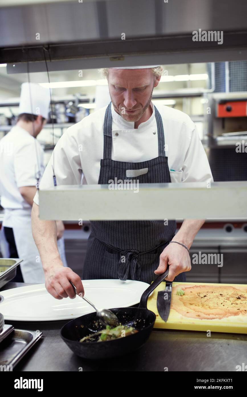 MasterChef al lavoro. Chef preparano un servizio di pasto in una cucina professionale. Foto Stock