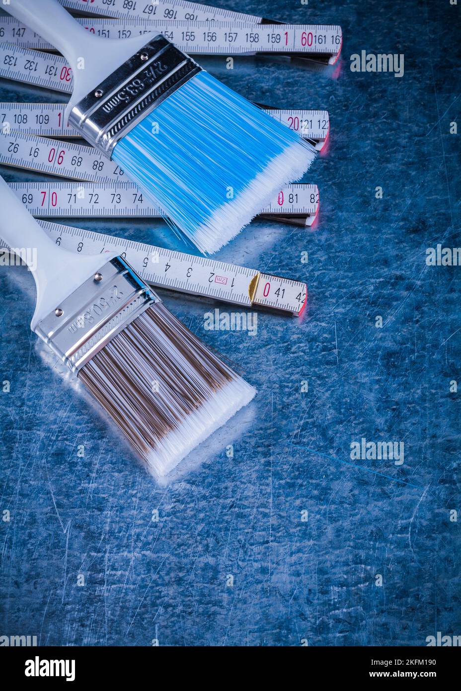 Vista ravvicinata dei pennelli in legno per metro su superficie metallica. Foto Stock