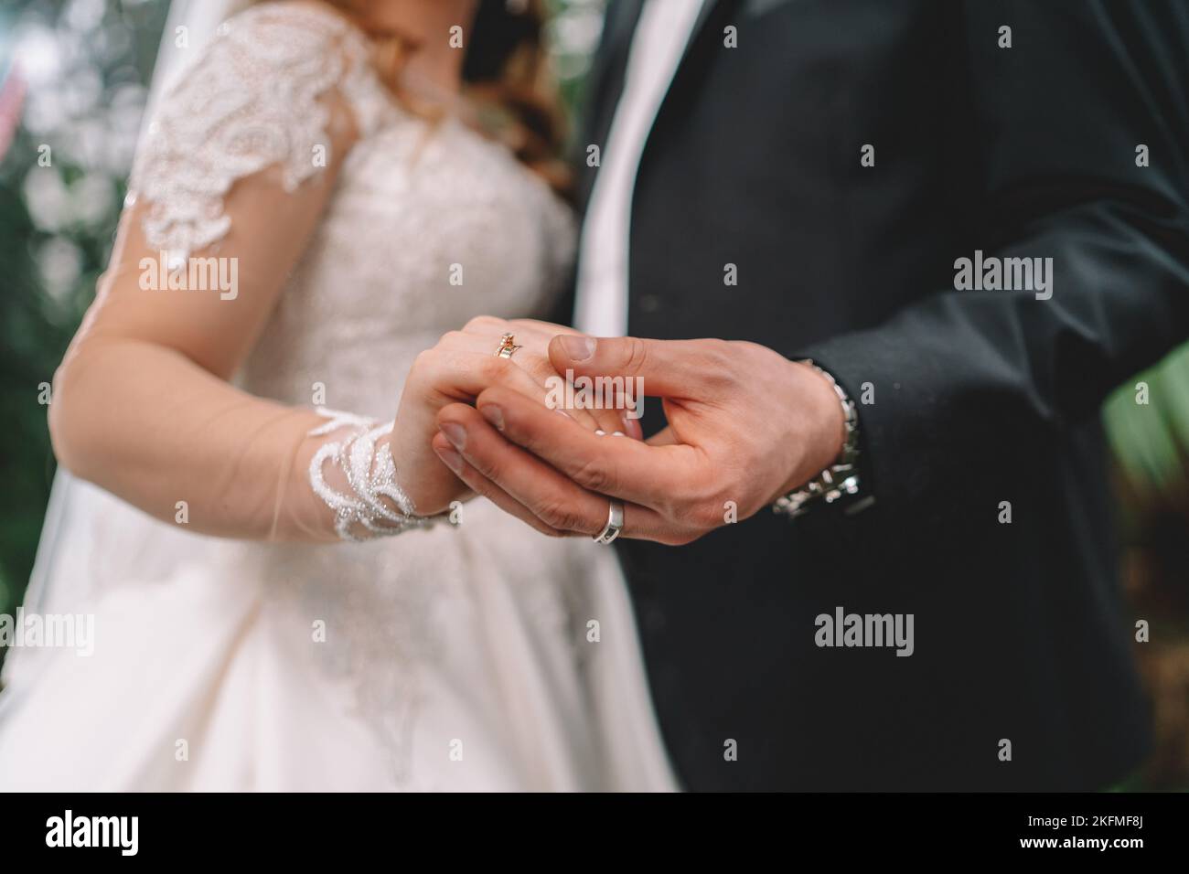 Un irriconoscibile sposa e lo sposo lo scambio degli anelli di nozze nella chiesa durante il cristiano la cerimonia nuziale Foto Stock