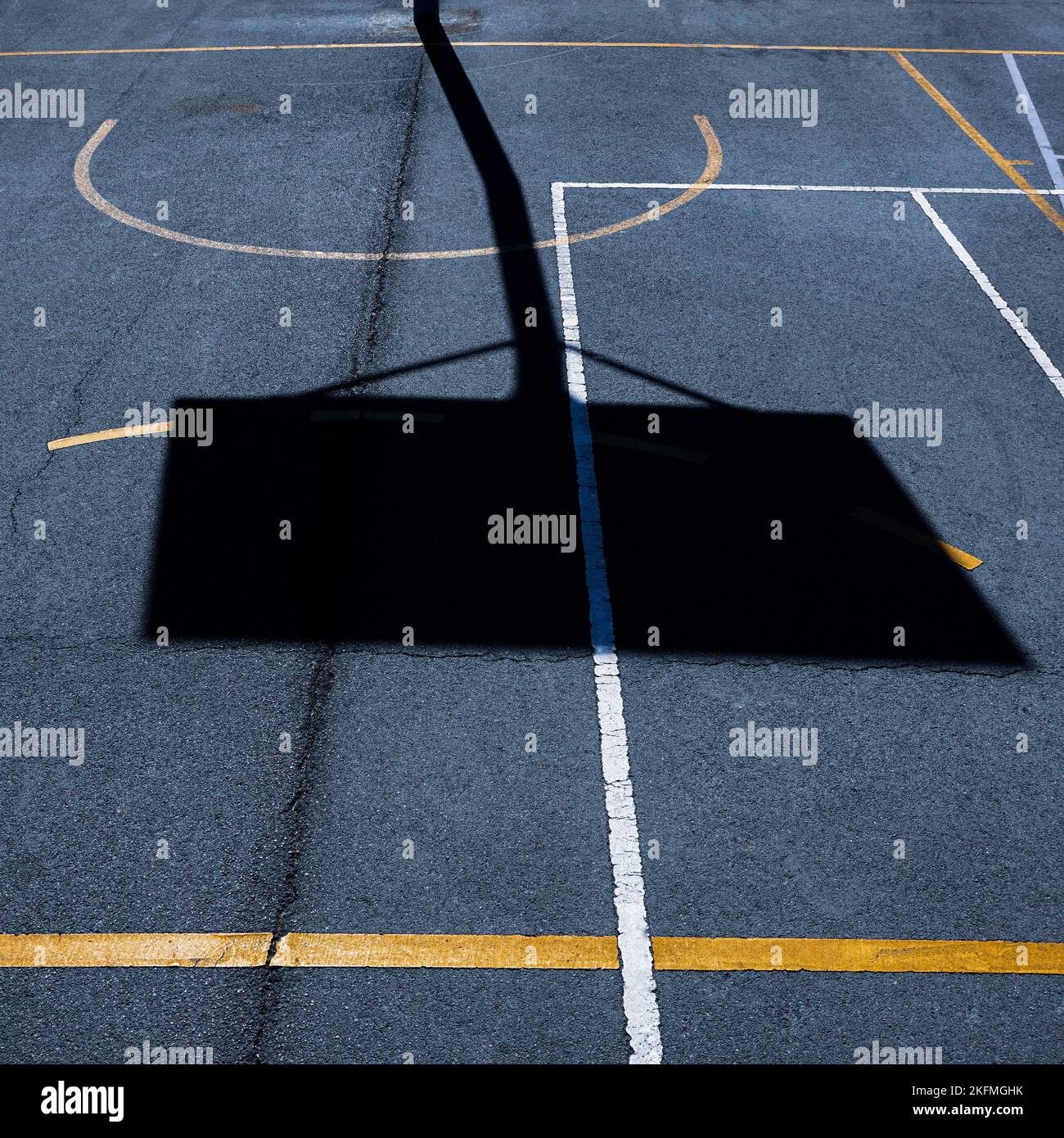 street basketballl hoop ombra sul campo sportivo Foto Stock