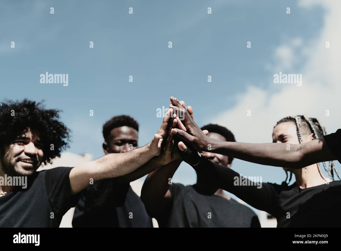 Felice gruppo di persone africane che hanno divertente accatastare le mani all'aperto Foto Stock