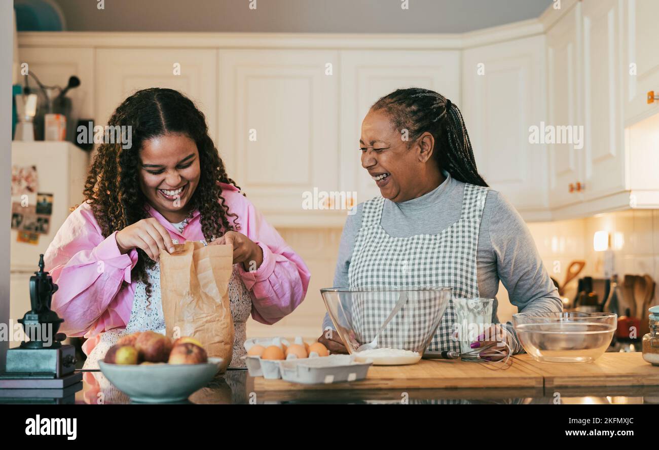 Buona madre africana e figlia che preparano un dessert fatto in casa Foto Stock