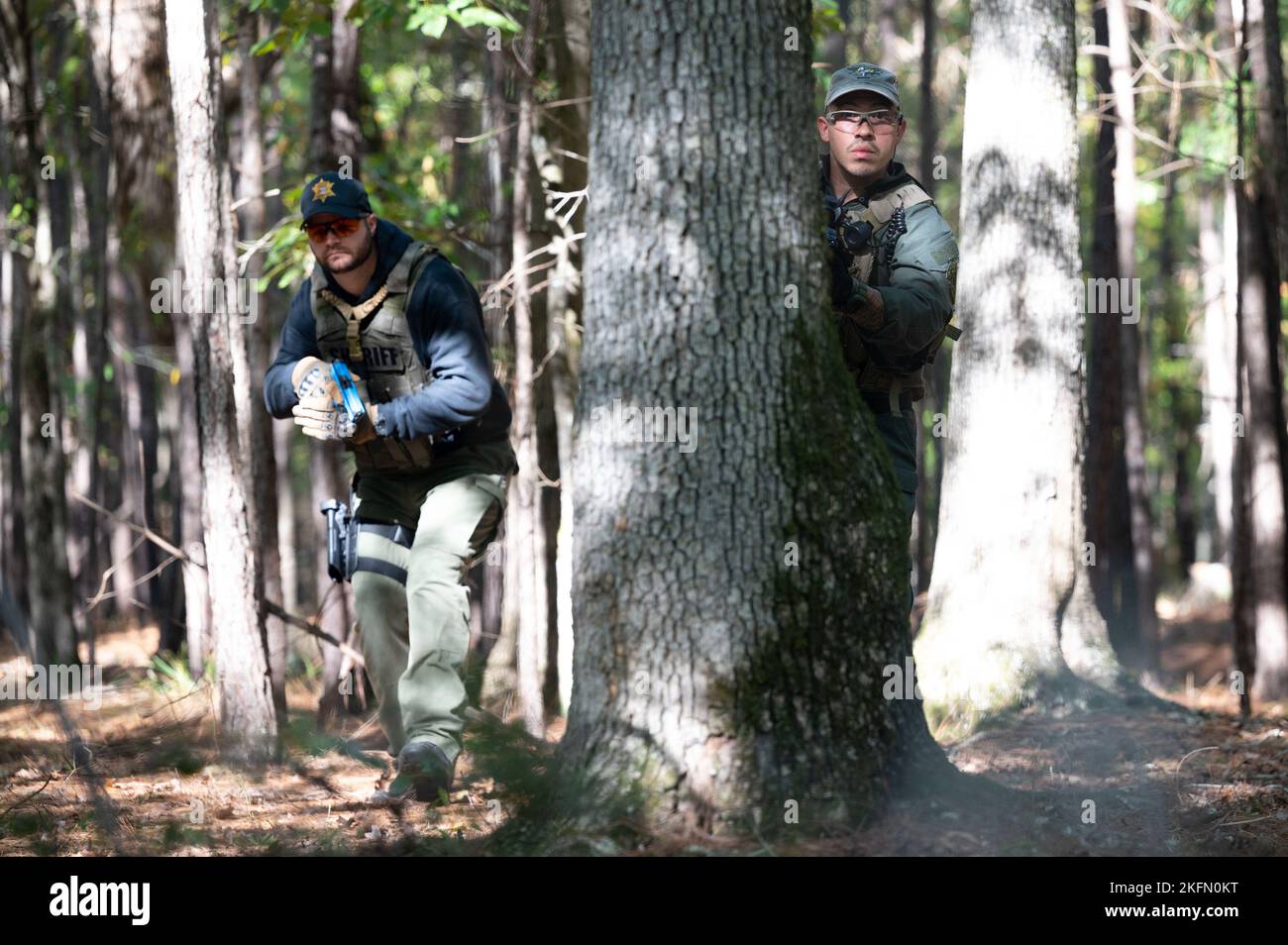 Chris Partridge, un vice di pattuglia dell'ufficio dello sceriffo della contea di Beaufort, si copre dietro un albero mentre persegue un sospetto con Tyler Leduc, un vice di pattuglia dell'ufficio dello sceriffo della contea di Pickens, durante un esercizio di addestramento del 27 settembre 2022 presso la South Carolina Criminal Justice Academy in Columbia. La South Carolina Criminal Justice Academy ha ospitato una settimana Federal Bureaus of Investigation Special Weapons and Tactics Summit per addestrare i funzionari delle forze dell'ordine in armi da fuoco, combattimenti ravvicinati, assistenza medica tattica, tattiche di pattugliamento e familiarizzare gli ufficiali con i dispositivi esplosivi improvvisati. Foto Stock