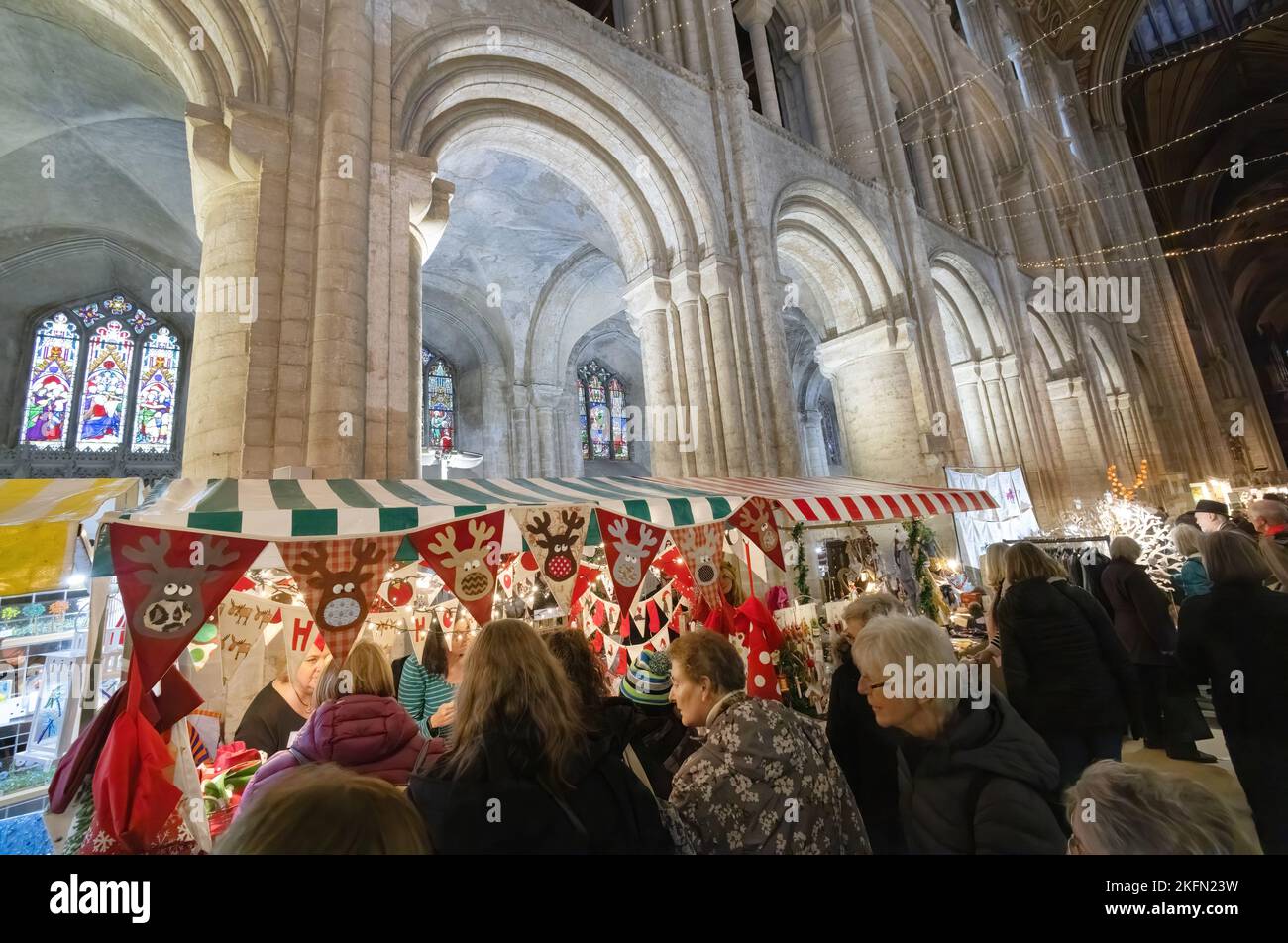 Fiera di Natale della Cattedrale di Ely - la gente che acquista al cibo e bancarelle del mercato dei regali a Natale, all'interno della cattedrale, Ely Cambridgeshire UK Foto Stock